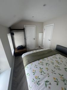 a bedroom with a bed with a floral bedspread at West Strand Snug in Portrush