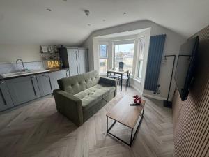 a living room with a couch and a table at West Strand Snug in Portrush