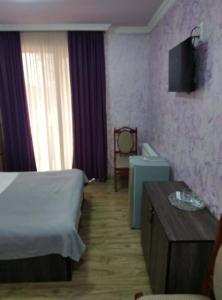 a hotel room with a bed and a table at Hotel Pagio in Chaisubani