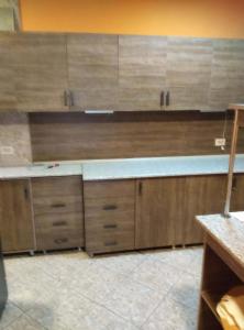 a kitchen with wooden cabinets and a counter top at Hotel Pagio in Chaisubani +15 photos