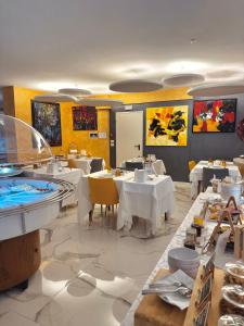 a restaurant with white tables and chairs in a room at Meublè Tripoli in Grado