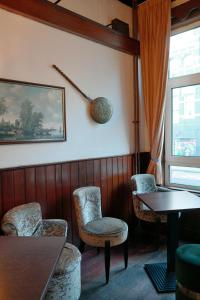 a room with chairs and a table and a window at Hotel Sphinx in Amsterdam