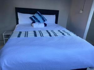 a blue bed with a blue pillow on top of it at Vumasky self catering in Ladysmith