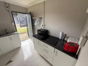 a kitchen with a black counter top and a microwave at Vumasky self catering in Ladysmith