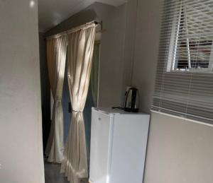 a kitchen with a white refrigerator and a window at Vumasky self catering in Ladysmith