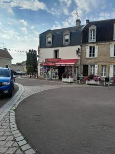 a blue car parked on a street next to a building at Maison Quebec in Bernières-sur-Mer