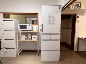 a kitchen with a refrigerator and a microwave at ura San Jose in Okayama