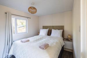 a bedroom with a large bed with two towels on it at Sfeervol boshuisje op de Veluwe Vossenberg in Nunspeet