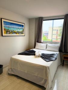 a bedroom with a large bed with a window at Pousada Elo Inn in Recife