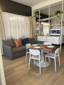 a living room with a couch and a table and chairs at pinetadamare in Porto SantʼElpidio