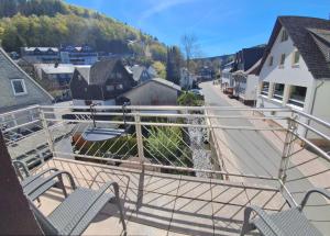 a balcony with chairs and a view of a town at Aparthotel Harlekin in Willingen