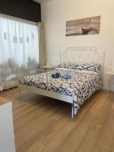 a bedroom with a bed with a blue and white comforter at pinetadamare in Porto SantʼElpidio
