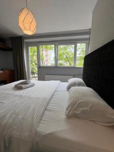 a large white bed with two pillows and a window at Boulevard Studios NewBorn in Prishtinë