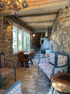 a living room with chairs and a stone wall at Dimitra Apartments in Milina
