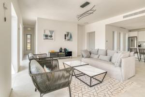 a living room with a couch and chairs and a table at Villa Ariadni Paros in Isterni