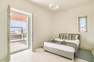 a bedroom with a bed and a sliding glass door at Villa Ariadni Paros in Isterni