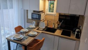 a kitchen with a table with chairs and a microwave at Gîte de la Pinsonnerie in Fondettes