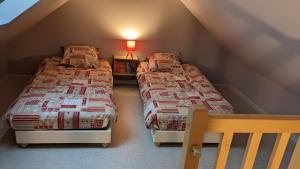 two twin beds in a attic bedroom with a staircase at Gîte de la Pinsonnerie in Fondettes