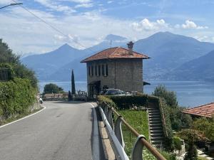 a road with a building on the side of a mountain at Panoramic Stone Retreat - Menaggio by LoveComo in Menaggio