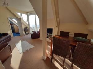 a living room with a wooden table and chairs at Shellsborough Penthouse in Woolacombe