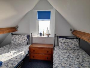 two beds in a attic room with a window at Shellsborough Penthouse in Woolacombe
