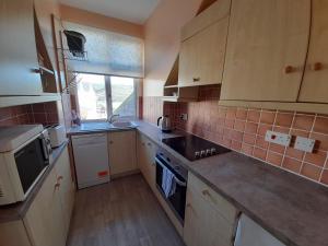 a kitchen with a sink and a stove top oven at Shellsborough Penthouse in Woolacombe