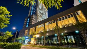 a building with a tall building at night at Shine Hotel Incheon Airport in Incheon