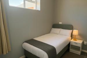 a small bed in a small room with a window at Evangeline House in Cape Town