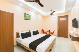 a bedroom with a bed and a table and chairs at Hotel O Happy Times Vishveshwar Park in Gomti Nagar