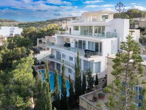 an aerial view of a white house with a swimming pool at Villa Marni in Xlendi