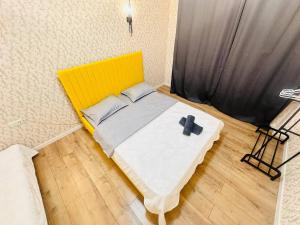 a yellow bed with a cross on it in a room at Гостевой Хаб у Сайрана 8 спальных мест у автовокзала in Almaty +26 photos