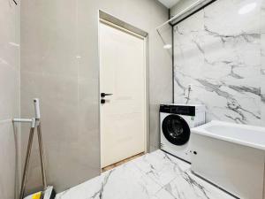 a white bathroom with a washing machine and a sink at Гостевой Хаб у Сайрана 8 спальных мест у автовокзала in Almaty