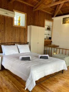 a large white bed in a bedroom with wooden walls at Melinda Tower in Plomari