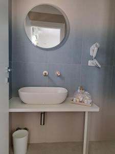 a bathroom with a white sink and a mirror at Venti Magici Rooms in Peschici +25 photos