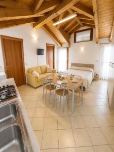a kitchen and living room with a table and a couch at Residence Mediterraneo - Agenzia Cocal in Caorle