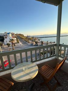 a table and chairs on a balcony with a view of the ocean at Afrodite Hotel in Tinos