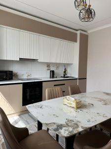 a kitchen with a large marble table and chairs at Guest hause ASEL in Kazarman +6 photos