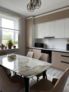 a kitchen with a dining room table and chairs at Guest hause ASEL in Kazarman