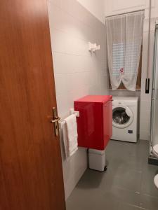 a bathroom with a washing machine and a red door at Una rosa sul mare Monopoli in Monopoli +7 photos