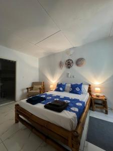 a bedroom with a large bed with blue pillows at Villa Mondoukou Beach in Île Bouët