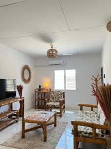 a living room with wooden furniture and a tv at Villa Mondoukou Beach in Île Bouët