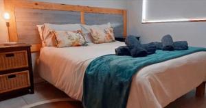 a bedroom with a bed with two stuffed animals on it at Hartmel Sea Deck in Hartenbos
