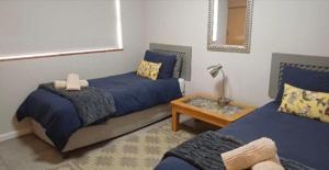 a bedroom with two beds and a table and a mirror at Hartmel Sea Deck in Hartenbos