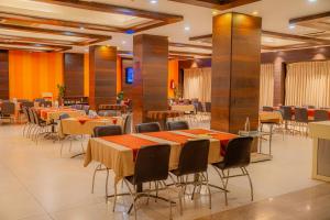 a restaurant with tables and chairs in a room at Hotel Prince Residency, Bhuj in Bhuj