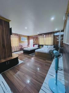 a room with two beds and a television in it at Hotel Aanandalok in Pānigata