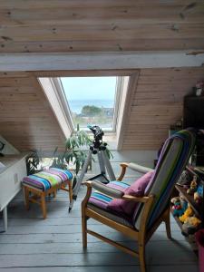 a room with two chairs and a camera in a attic at Høgberget Loft with 3 bedrooms and private bathroom in Skotten +8 photos