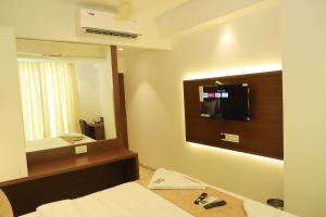 a hotel room with a bed and a mirror at Sapphire Suites in Navi Mumbai +75 photos