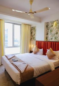 a bedroom with two beds and a large window at Sapphire Suites in Navi Mumbai