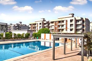 a swimming pool in front of some apartment buildings at Modern chic rooftop studio in Sheikh Zayed