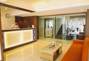 a man in a living room with a couch and a table at Sapphire Suites in Navi Mumbai